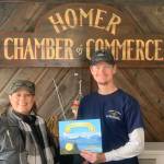 Terry Busch (left) and her son, Aaron Busch, from California pick up an End of the Road certificate at the Homer Chamber of Commerce Spit Visitor Center on Thursday, May 25, 2023 in Homer, Alaska. Photo by Christina Whiting