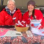 Colleen Wagner and Brianna Bahl distribute paper poppies on Memorial Day weekend outside Safeway on behalf of the American Legion in Homer, Alaska. Photo by Christina Whiting