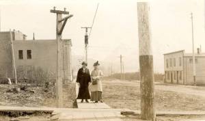 Photo #1.628 courtesy of the Seward Community Library Association
Dr. John Baughmans wife, Mina (left), poses in this circa 1905-10 photo with Mrs. E.E. Hale on a Seward city sidewalk near the Alaska Central Railroad and Sewards first school.
