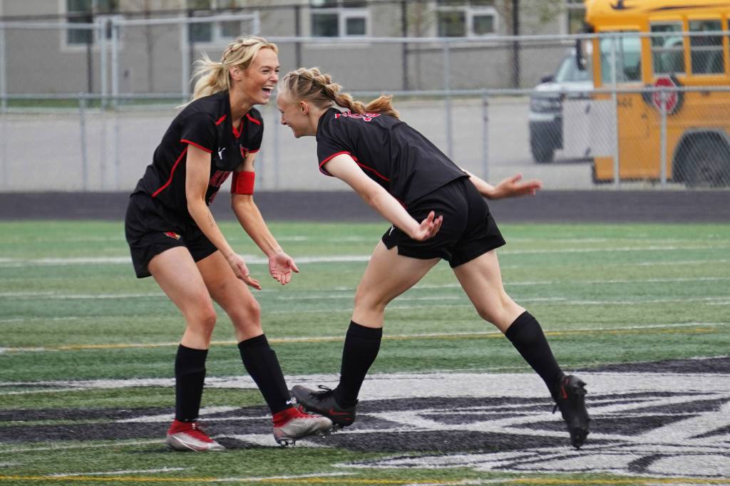 Kenai Centrals Calani Holmes and Rylie Sparks celebrate after Sparks scored their first goal of the game during the Division II Soccer State Championship on Saturday, May 27, 2023, at West Anchorage High School in Anchorage, Alaska. (Jake Dye/Peninsula Clarion)