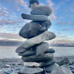 A rock cairn and half moon are pictured on Tuesday, May 30, 2023 at the Lands End Resort beach in Homer, Alaska. Photo by Christina Whiting