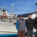 Second captain Mike Tozzo, chef Avram Salzman, and captain and owner Rand Seaton pose in front of the Lady of the Sea on Thursday, June 1, 2023 in the Homer Harbor in Homer, Alaska. Photo provided by Lauren Seaton