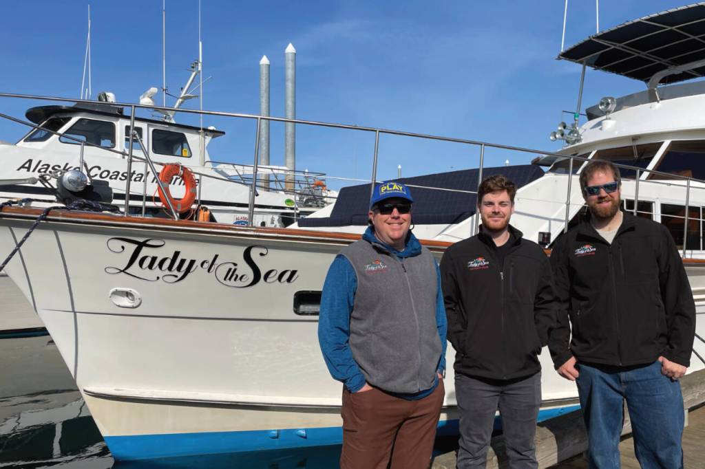 Second captain Mike Tozzo, chef Avram Salzman, and captain and owner Rand Seaton pose in front of the Lady of the Sea on Thursday, June 1, 2023 in the Homer Harbor in Homer, Alaska. Photo provided by Lauren Seaton