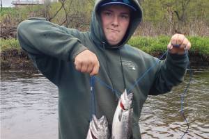 Hunter Kirby holds up the hatchery king salmon he bagged during the one-day youth fishery on the Ninilchik River on Wednesday, June 7, 2023 in Ninilchik, Alaska. Photo by Mike Booz