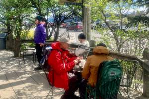 Visitors enjoy coffee and treats along a boardwalk on the Homer Spit on Wednesday, June 14, 2023 in Homer, Alaska. Photo by Christina Whiting