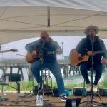 Homer youth musician Silas Jones performs on stage alongside U.S. military veteran musicians Shannon Book and Brandon Mills during the Homer Chamber of Commerce and Visitor's Center Summer Solstice Festival on Wednesday, June 21, 2023 at the Deep Water Dock n Homer, Alaska. Photo by Christina Whiting