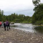 Community members watch yellow ducks, the first color category, run down the Anchor River during the Fourth of July Duck Race on Sunday, July 2, 2023 in Anchor Point, Alaska. (Delcenia Cosman/Homer News)