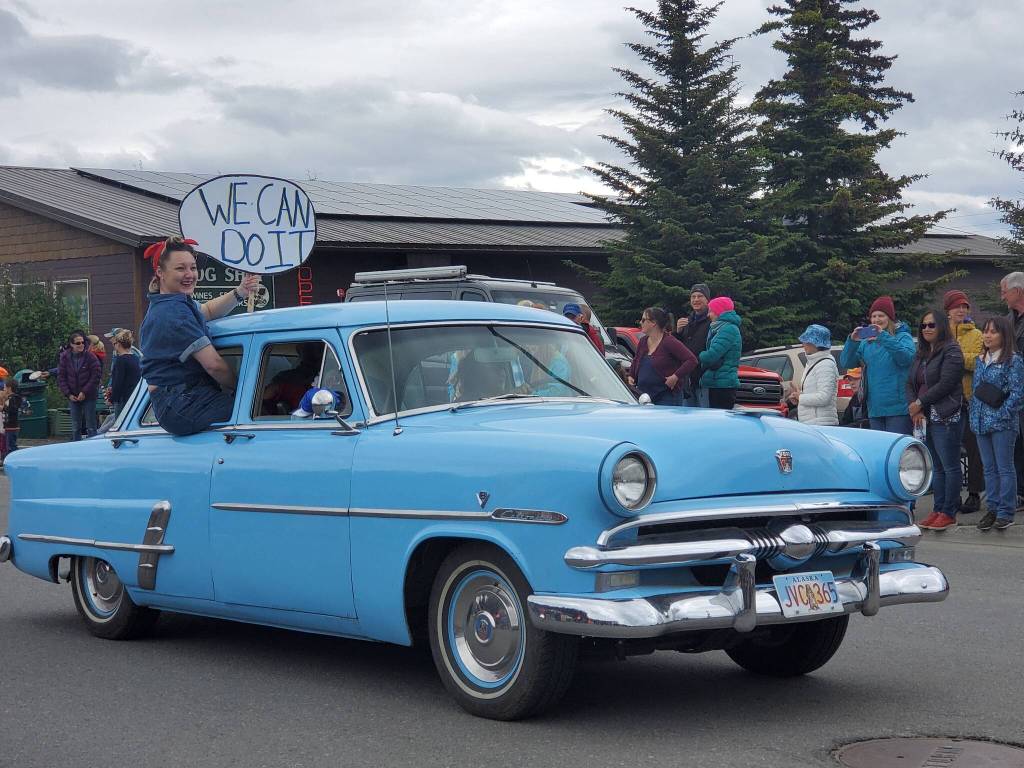 Rosie the Riveter waves from the window of an old Ford to crowds gathered on Pioneer Avenue during the Seas the Day parade on Tuesday, July 4, 2023 in Homer, Alaska. (Delcenia Cosman/Homer News)