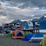 Colorful tents are pitched in the foreground of a boardwalk on the Homer Spit during Fourth of July weekend on Sunday, July 2, 2023 in Homer, Alaska. Photo by Christina Whiting