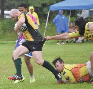 Photos by Jeff Helminiak/Peninsula Clarion
Ruairi Tuite of the Kenai River Wolfpack tries to break the tackles of Edgar Luna (top) and Keith McDaniel of the Fairbanks SunDawgs on Saturday at the Between the Tides Rugby Tourney at Millennium Square Field in Kenai.