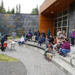 A crowd watches a smoked salmon demonstration, part of Fish Week 2023, on Wednesday, July 19, 2023, at the Kenai National Wildlife Refuge Visitor Center in Soldotna, Alaska. (Jake Dye/Peninsula Clarion)