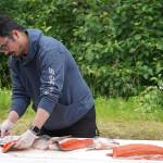 James Wardlow demonstrates filleting a salmon with an ulu during a smoked salmon demonstration, part of Fish Week 2023, on Wednesday, July 19, 2023, at the Kenai National Wildlife Refuge Visitor Center in Soldotna, Alaska. (Jake Dye/Peninsula Clarion)