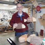 Homer woodworker Ted Heuer in photographed in his shop with rockfish and halibut trivets in 2022. Photo by Beth Heuer