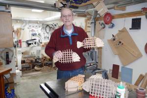 Homer woodworker Ted Heuer in photographed in his shop with rockfish and halibut trivets in 2022. Photo by Beth Heuer
