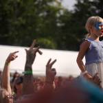 Mynarae Glover stands on her father, James Glovers shouders during a performance by Medium Build on the River Stage at Salmonfest in Ninilchik, Alaska, on Friday, Aug. 4, 2023. (Jake Dye/Peninsula Clarion)