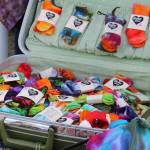 Tie dye socks fill a suitcase at Jen Luton's Drunken Forest Tie Dye booth at Salmonfest on Friday, Aug. 4, 2023 in Ninilchik, Alaska. (Ashlyn O'Hara/Peninsula Clarion)