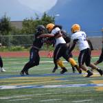 A Homer High Mariner blocks the Barrow Whalers Norm Lilomaiava at the home opener varsity football game on Saturday, Aug. 12, 2023 in Homer, Alaska. (Delcenia Cosman/Homer News)