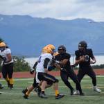 Homers Preston Stanislaw defends the ball from Barrow in the third quarter before passing it to Jonah Martin, who scores a touchdown and brings the Mariners score up to 36 points during the home opener varsity game on Saturday, Aug. 12, 2023 in Homer, Alaska. (Delcenia Cosman/Homer News)