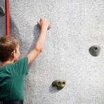 Arthur Steward, left, scales the rock wall at the Kenai Peninsula Fair in Ninilchik, Alaska, on Friday, Aug. 11, 2023. (Jake Dye/Peninsula Clarion)