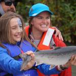 Lillian Bohman holds up a salmon she caught during the Kenai River Junior Classic in Soldotna, Alaska, on Wednesday, Aug. 9, 2023. (Jake Dye/Peninsula Clarion)