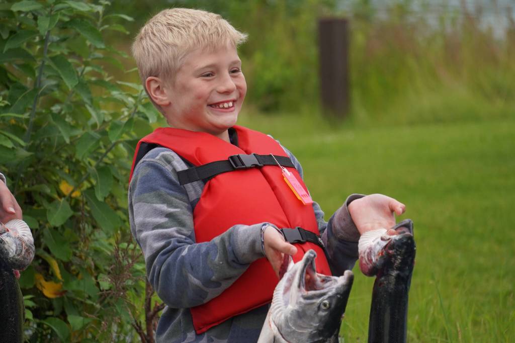 Tanner Poe holds up a salmon he caught during the Kenai River Junior Classic in Soldotna, Alaska, on Wednesday, Aug. 9, 2023. (Jake Dye/Peninsula Clarion)