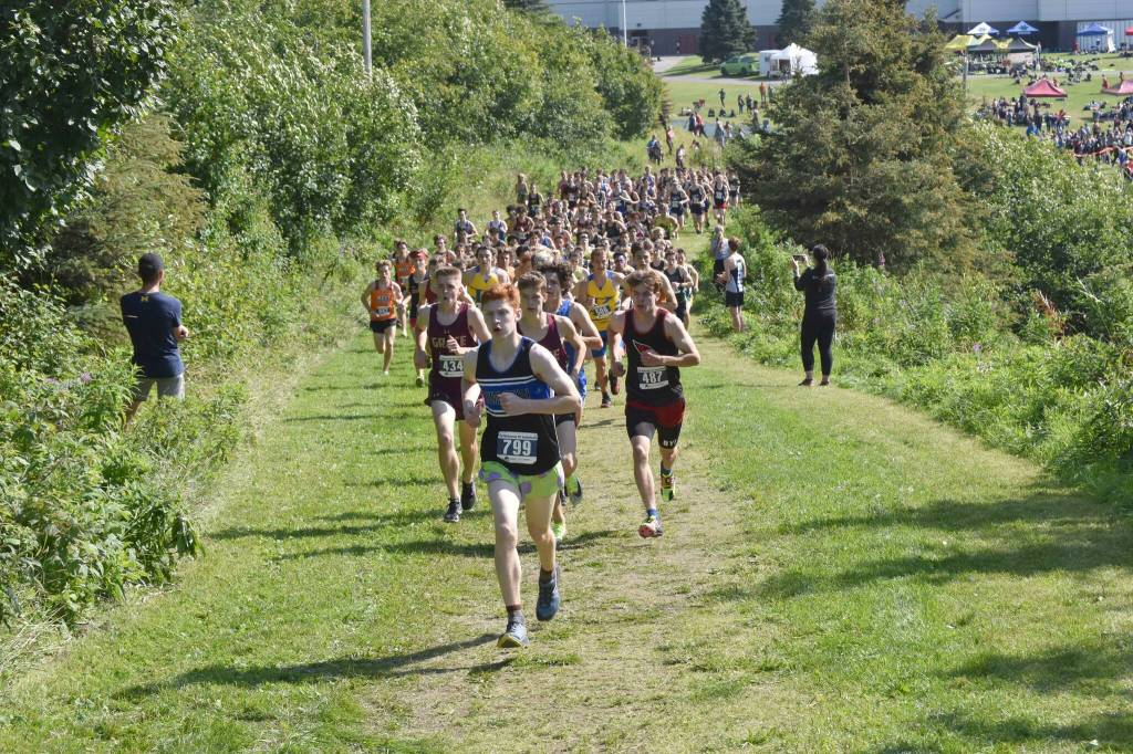 Erik Thompson of Juneau-Douglas: Yadaa.at Kale leads the pack up a hill at the beginning of the boys varsity race at the Ted McKenney Invitational on Saturday, Aug. 19, 2023, at Tsalteshi Trails just outside of Soldotna, Alaska. (Photo by Jeff Helminiak/Peninsula Clarion)