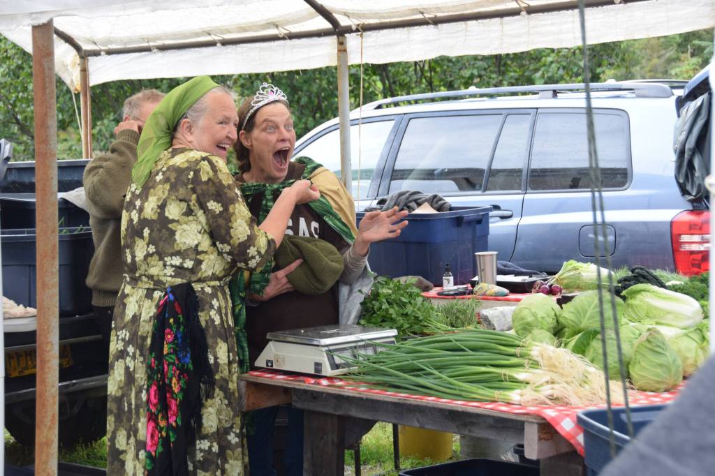 Jen Castellani from Will Grow Farm (right) is crowned the new Zucchini Queenie by the former queen, Luba Dorvall from Lubas Garden (left) at the Homer Farmers Market Zucchini Festival on Saturday, Aug. 26, 2023 in Homer, Alaska. (Delcenia Cosman/Homer News)