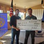 Homer-Kachemak Rotary Club president Owen Meyer (right) presents a donation check to Altruist Relief Kitchen founder Lucas Wilcox (left) on Tuesday, Aug. 15, 2023 in Homer, Alaska. Photo provided by Kim Zook