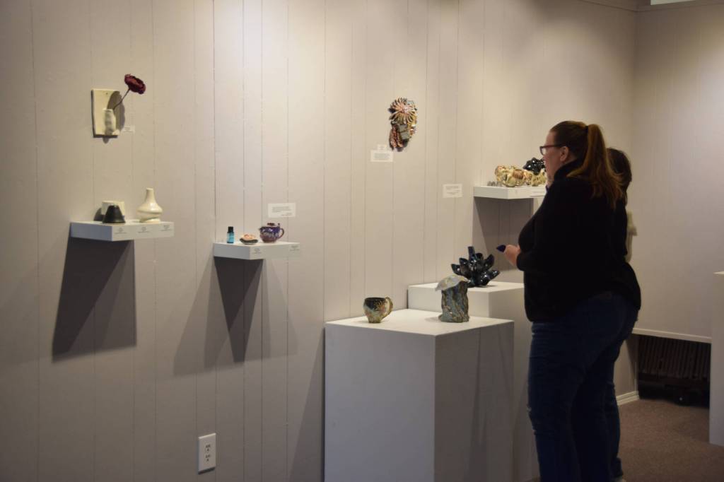 Community members peruses the ceramics on display at Homer Council on the Arts First Friday showcase on Sept. 1 in Homer, Alaska. (Delcenia Cosman/Homer News)