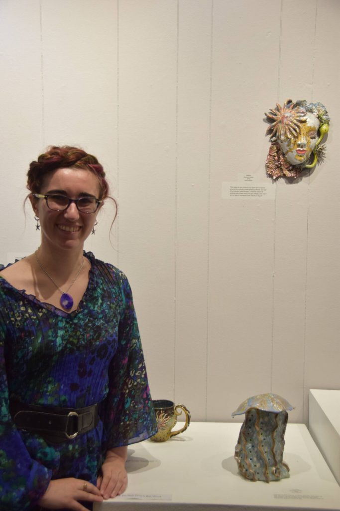 Artist Shannon Cefalu poses next to her handbuilt ceramics on display at Homer Council on the Arts First Friday showcase on Sept. 1 in Homer, Alaska. (Delcenia Cosman/Homer News)