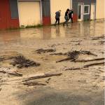 The Bagel Shop employees and owner Mikela Aramburu wade through the mud to get to the shop on Saturday, Aug. 26, 2023 in Homer, Alaska. Photo provided by Mikela Aramburu