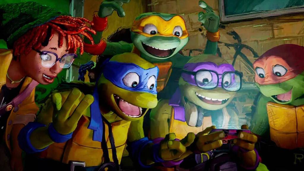 April ONeil, Leonardo, Michelangelo, Donatello and Raphael gather around a cell phone in Teenage Mutant Ninja Turtles: Mutant Mayhem. (Photo courtesy Paramount)