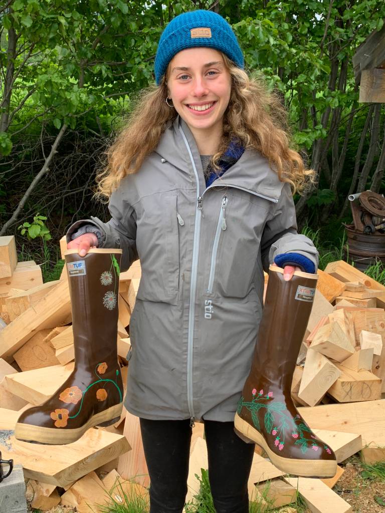 Homer youth artist Daisy Walker poses with a pair of Xtra Tuff boots she painted for a community member in the summer of 2023. Photo by Christina Whiting