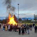 Students and community members gather around a bonfire in the Homer High School parking lot after the homecoming football game on Friday, Sept. 8, 2023 in Homer, Alaska. (Delcenia Cosman/Homer News)