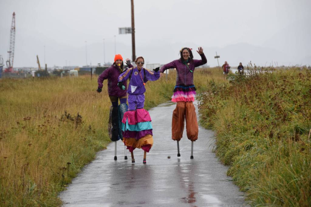 (from left to right) Drue Smith, Annie Garay and Mallory Primm of the Sealegs Stilt Troupe dance toward the finish line in the first annual 5K Run for Recovery on Saturday, Sept. 16, 2023 on the Spit in Homer, Alaska. (Delcenia Cosman/Homer News)