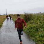 Runner Martin Shuster crosses the finish line first in the 5K Run for Recovery on Saturday, Sept. 16, 2023 on the Spit in Homer, Alaska. Shuster was awarded a prize for "First Place Adult Man" in the ceremony following the race. (Delcenia Cosman/Homer News)
