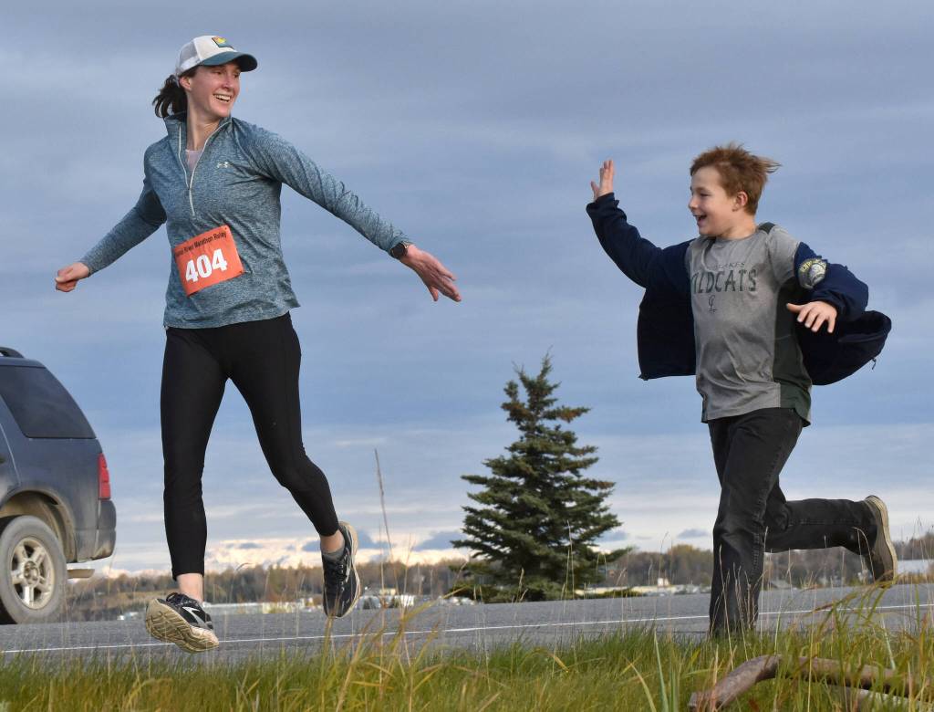 Amy Anderson gets encouragement from her son, Everett, in the marathon relay at the Kenai River Marathon on Sunday, Sept. 24, 2023, in Kenai, Alaska. Anderson teamed with Bethany Nyboer, Katy Coseglia and Chelsea Wingard to finish fourth with Soar B.A.C.K.s. (Photo by Jeff Helminiak/Peninsula Clarion)