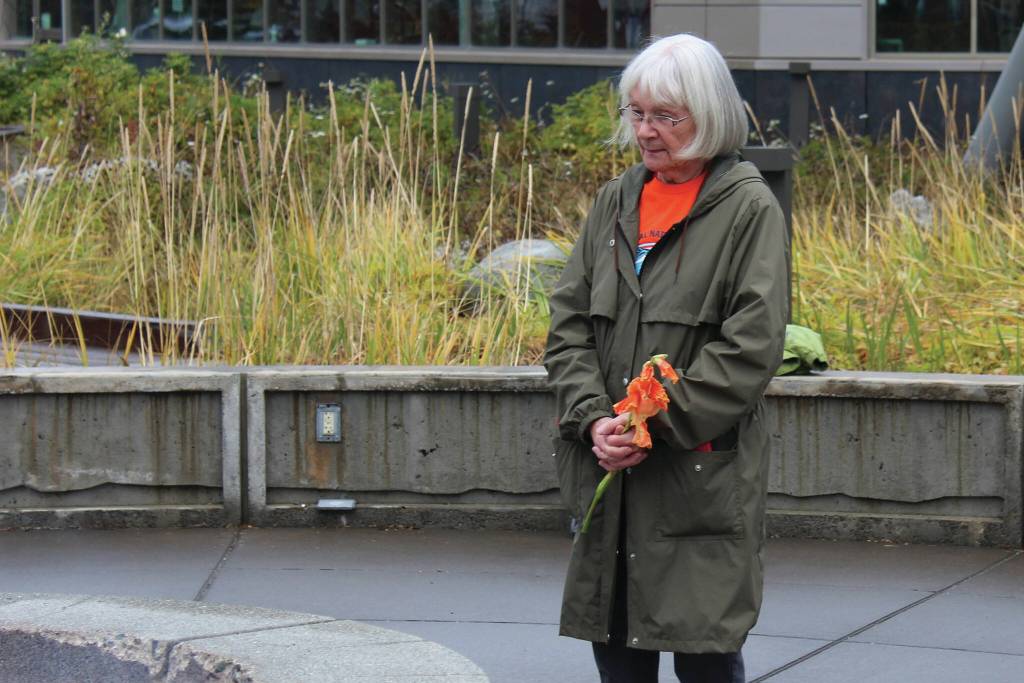 Ashlyn OHara/Peninsula Clarion
Mary Hunt, a survivor of Holy Cross Mission, holds flowers during an Orange Shirt Day ceremony at Ggugguyni Tuh, Raven Place, outside the Denaina Wellness Center on Oct. 6 in Kenai.