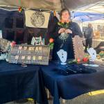 Artist Carley Conemac is photographed at her Homer Farmers Market booth in July 2023. Photo by Syd Paulino