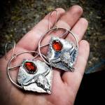Hand-fabricated sterling silver hoops with silver clay cow skulls and two-step cut garnet cabochons were created by Homer artist Carley Conemac this past July. Photo provided