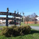 The sign at the entrance of Kenai Peninsula Colleges Kachemak Bay Campus is photographed, with Youngs Downtown Inn in the background on the right, on Friday, Oct. 20, 2023 in Homer, Alaska. (Finn Heimbold/Homer News)