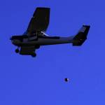 A pumpkin is released from a plane during Kenai Aviations Fifth Annual Pumpkin Drop at the Kenai Airpark in Kenai, Alaska, on Saturday, Oct. 21, 2023. (Jake Dye/Peninsula Clarion)