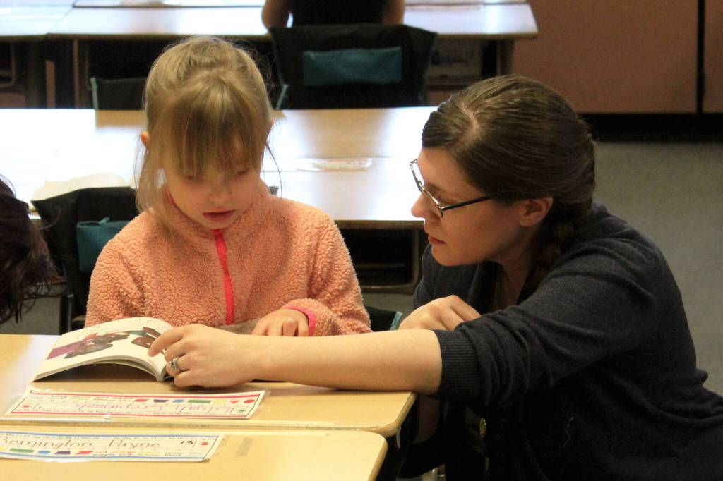 Mountain View Elementary School first grade teacher Kristin Perkins helps a student read aloud on Thursday, Oct. 19, 2023, in Kenai, Alaska. (Ashlyn OHaara/Peninsula Clarion)