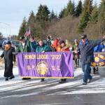Members of the Homer Elks Lodge and Emblem Club marching in the Veterans Day parade wave to cars honking in greeting on the Sterling Highway by the Alaska Maritime National Wildlife Refuge Visitor Center on Saturday, Nov. 11, 2023 in Homer, Alaska. (Delcenia Cosman/Homer News)