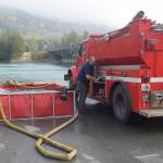 A firefighter from Cooper Landing Emergency Services refills a water tanker at the banks of the Kenai River in Cooper Landing, Alaska on Aug. 30, 2019. (Photo by Brian Mazurek/Peninsula Clarion)
