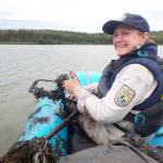 Friends of Alaska National Wildlife Refuges volunteer Beth Sullivan surveys for the invasive plant elodea at Campfire Lake on the Kenai National Wildlife Refuge on Aug. 30, 2023. Here she pulled up a rake full of star duckweed (Lemna trisulca). (Photo by Matt Bowser/USFWS)