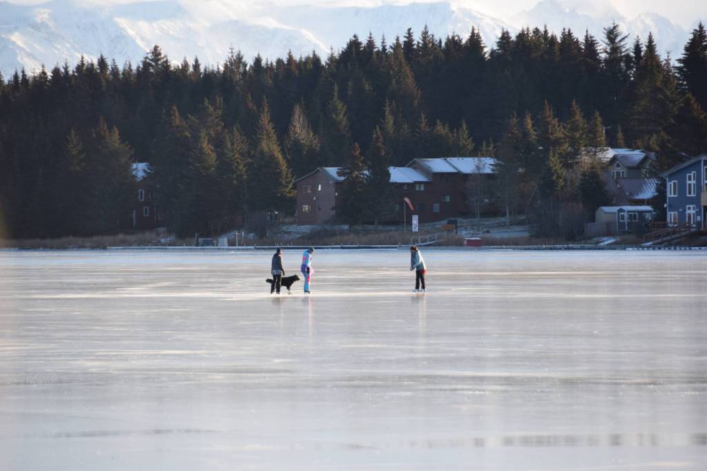 Skaters play on the frozen Beluga Lake, enjoying the sunshine on Monday, Nov. 20, 2023 in Homer, Alaska. (Delcenia Cosman/Homer News)
