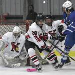 Kenai Centrals Seanna Swanson scrambles to make a save while Cole Langham and Kylee Verkuilen hold off Palmers Elijah Von Gunten on Nov. 16, during Kenai River Cup play at the Kenai Multi-Purpose Facility in Kenai. (Photo by Jeff Helminiak/Peninsula Clarion)