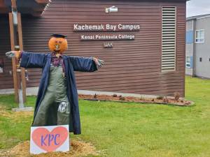 A friendly, pumpkin-headed scarecrow stands outside the Pioneer Avenue entrance of Kachemak Bay Campus on Thursday, Nov. 2, 2023 in Homer, Alaska. (Delcenia Cosman/Homer News)