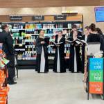 Members of the Homer High School Swing Choir advanced ensemble practice performing in front of the community in front of the Safeway deli on Wednesday, Dec. 6, 2023 in Homer, Alaska, ahead of their Candlelight, Carols and Desserts concert event on Thursday, Dec. 14. (Callie Steinberg/Homer News)